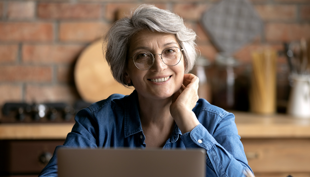 Smiling woman with grey hair wearing glasses