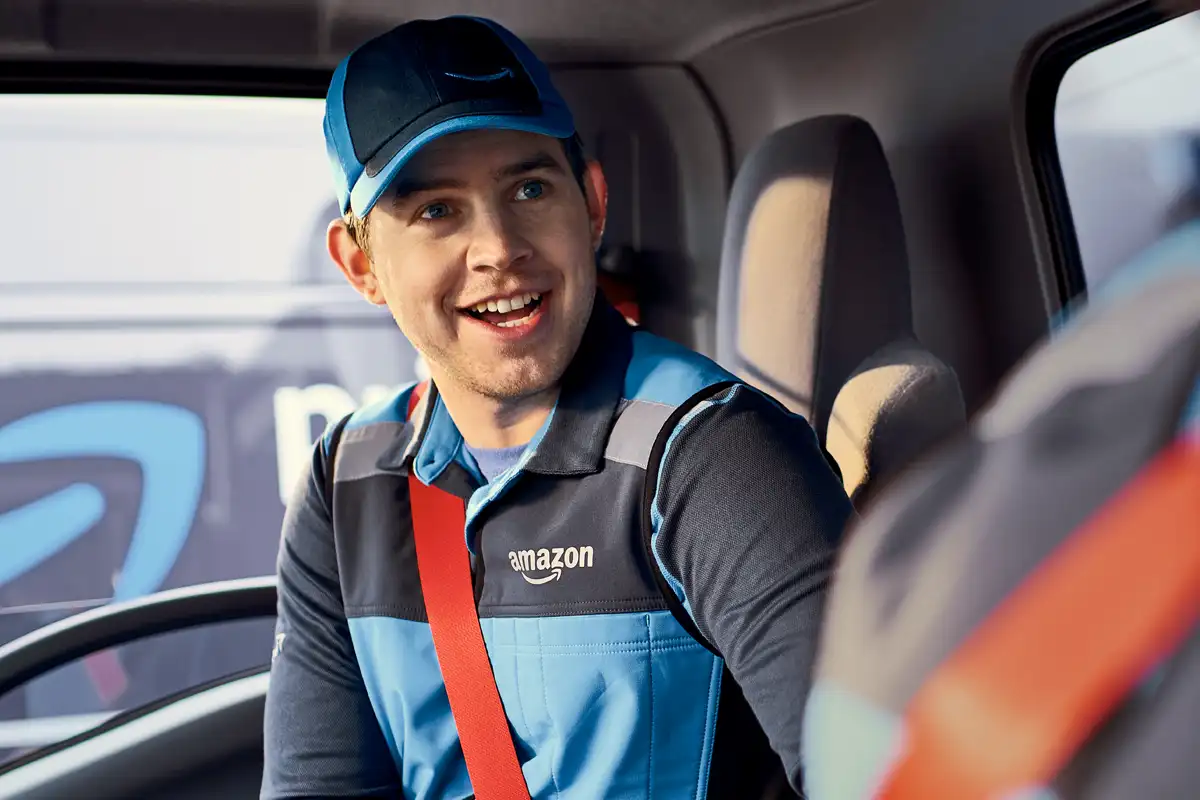Male Amazon Delivery Associate in an Amazon delivery van smiling and ...